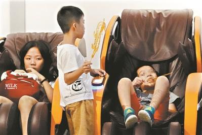 天河区一地下商场，有小朋友躺在按摩椅上吃东西，希望家长能注意孩子安全。广州日报全媒体记者莫伟浓 摄