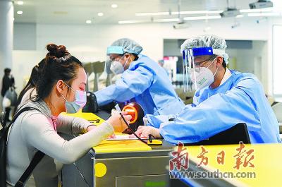 广州白云机场海关关员指导旅客填报《健康申明卡》。广州海关供图