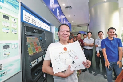 佛山市富粥一世海鲜酒家法人胡志强在南海区行政服务中心自助打印了《食品经营许可证》。珠江时报记者/方智恒摄