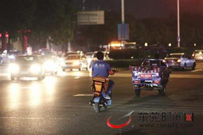 宏图路与城市风景街红绿灯路口,快递小哥和三轮车乱穿马路