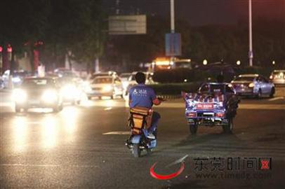 宏图路与城市风景街红绿灯路口，快递小哥和三轮车乱穿马路