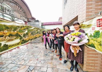 黄绮华将绣好的《清明上河图》挂在院子里展示。