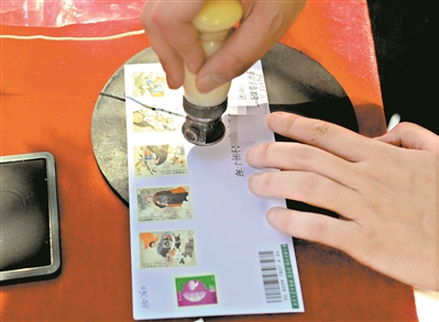 首发仪式上,集邮爱好者在邮票上加盖邮