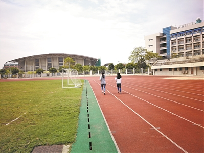广州大学两名女生在操场长跑。