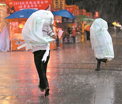 没带伞的路人套上超大塑料袋在街上狂奔。 广州日报全媒体记者黎旭阳摄