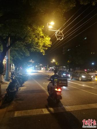 6月27日，北京簋街，外卖小哥在送单。张渺/摄