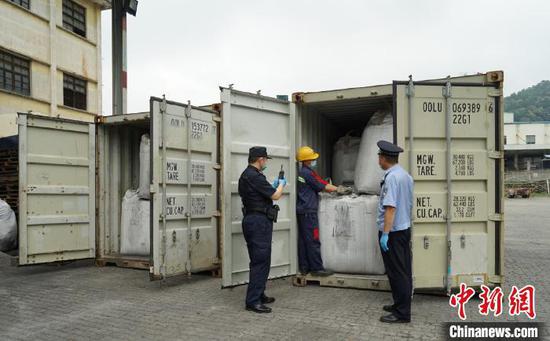 广州海关关员和缉私警察对计划退运的固体废物进行开柜查验。 关悦 摄