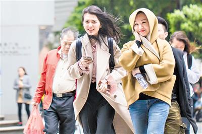 昨日降温，街头行人们捂紧了衣服。广州日报全媒体记者陈忧子摄