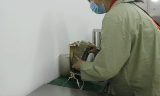 复核班班长黄少芳将复核之后的1000张纸币用捆扎机捆扎,整齐摆放在桌面上。