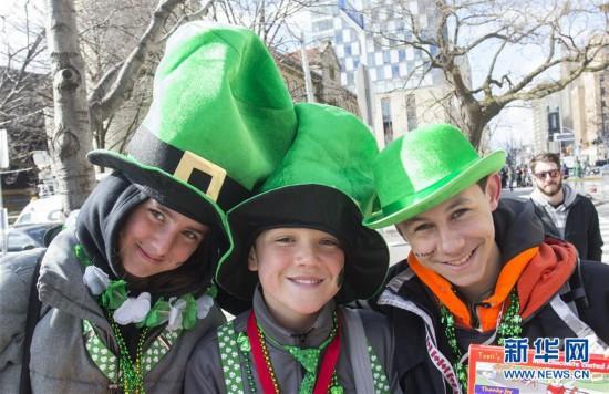 3月11日，在加拿大多伦多，三名少年在圣帕特里克节游行中合影。