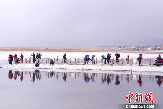 图为茶卡盐湖景区内，游客进入湖心腹地拍照留影。　马铭言 摄