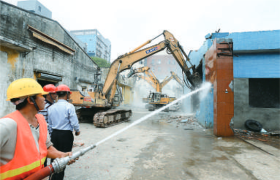 容桂街道海尾德龙智造科技园项目举行启动仪式后，多台机器在对旧厂房进行拆除，工人用水枪作压尘处理。