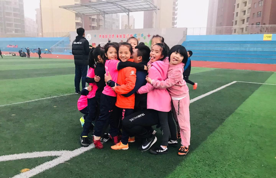 (图注:安浩然被孩子们紧紧抱住)