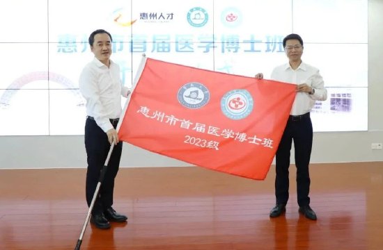 惠州市委组织部副部长张龙（右）为博士研修班授班旗