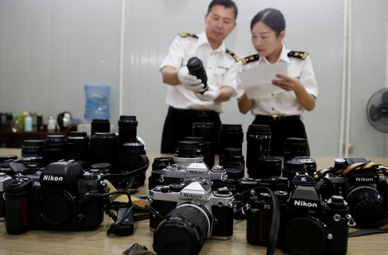 图为九洲海关关员清点查获的摄影器材 俞波摄