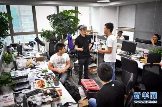 　　在深圳科技园的大疆创新总部，民用无人机领军者汪滔（中）参与研发人员的讨论（2015年5月22日摄）。新华社记者 毛思倩 摄