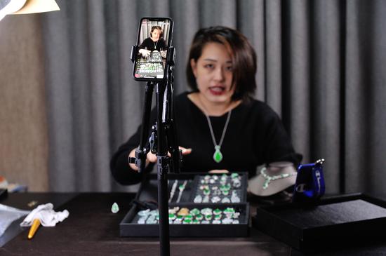 一名主播正在向直播间的粉丝介绍货品