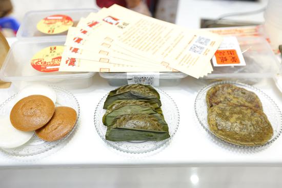 (新闻发布会现场非遗食品展示)