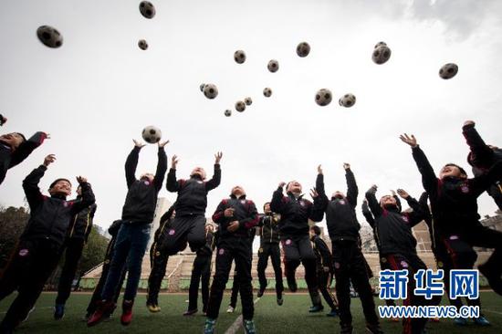 2015年3月2日,全国校园足球联赛定点学校的小球员们将足球抛向空中,迎接开学