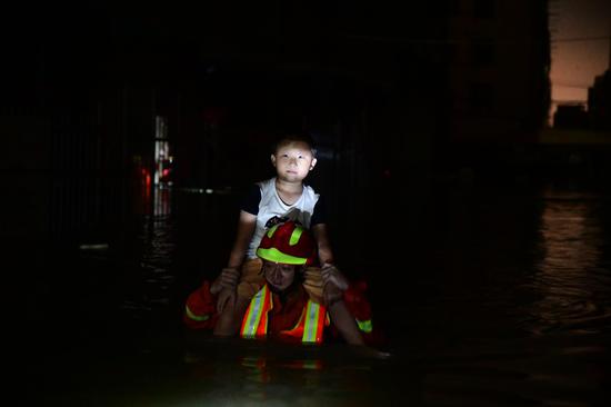 汕头市公安消防支队官兵将7岁大男童扛在肩上涉水送往安全地带