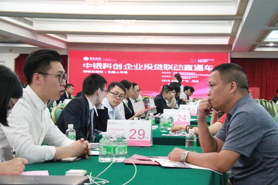 与参加活动的机器人企业现场洽谈