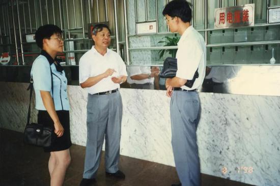 1998年8月1日，张荣桐（中）为客户解释供电服务承诺。