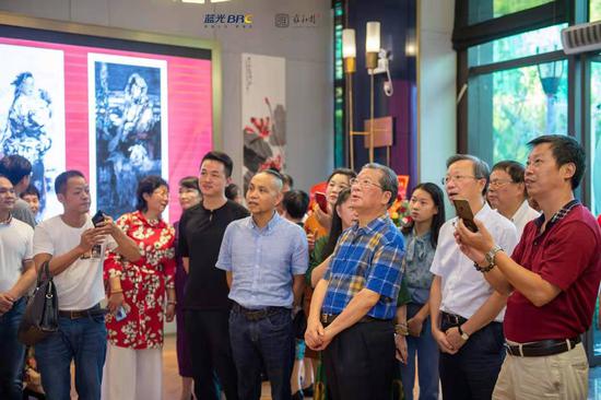 开幕式后,现场的领导和嘉宾在参观邱楚莲的精品佳作