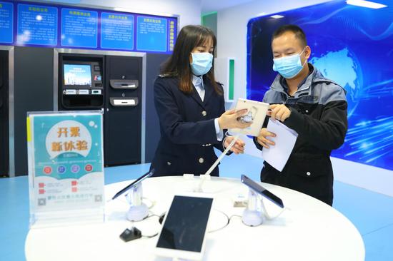(图为税务青年邹月明辅导纳税人使用电子税务局办理涉税事项)