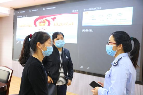 (图为税务青年陈观珍与赶来直播间现场的纳税人开展面对面交流)
