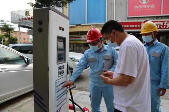 南方电网广东东莞东区供电局工作人员为充电桩客户解答疑问。罗敏仪 摄