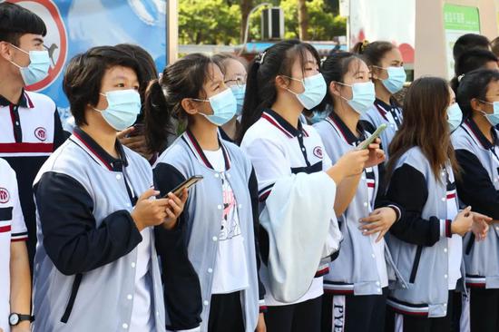 学生在户外全神贯注观看演练