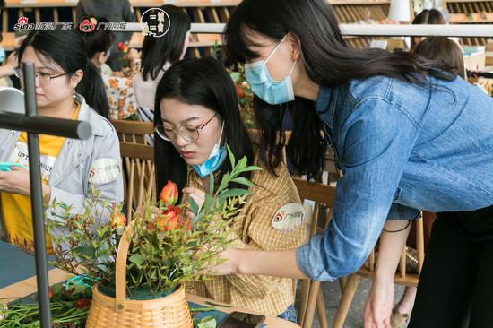 花艺师指导成员们微调花篮
