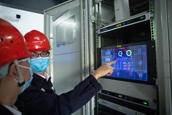南方电网广东江门江海供电局人员正通过智能电房的可视化触摸屏实时监控设备的各项数据情况。(温雯 摄)