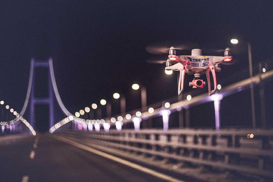 在南沙大桥上展翅翱翔的5G无人机(林韵 摄)