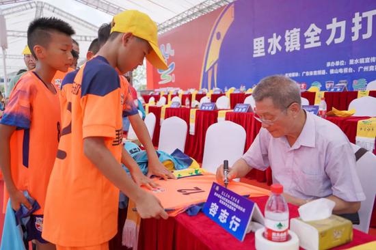 原中国足球协会副主席、中国足球名宿容志行为小球迷签名。