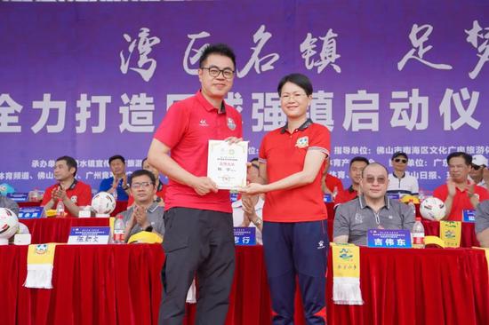 里水镇党委书记谭艳玲为广东体育届著名足球评述员和体育赛事主持人陈宁颁发“里水镇足球宣传大使”牌匾。