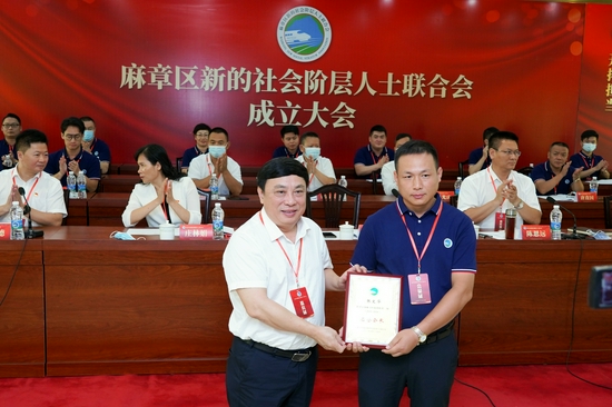 湛江市委统战部常务副部长庞安杰向新聘任名誉会长张文华颁发聘书