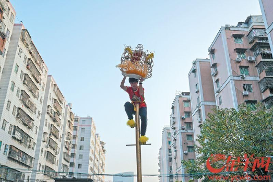 　　8日，广州员村，广州市泰晟龙狮团的16岁少女陈祉嫣在高竿上练“一柱擎天”。已经练舞狮三年的她武术功底良好，如今是队里的大师姐