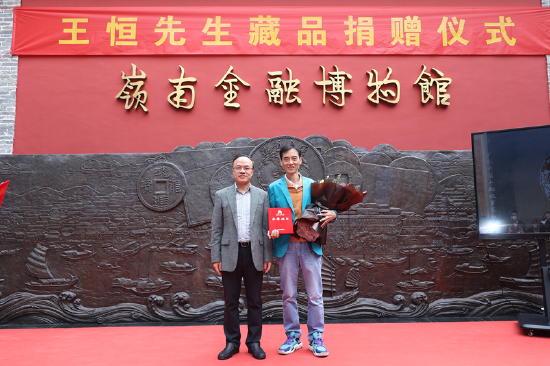 广州市地方金融监管局局长邱亿通(左)为王恒先生(右)颁发藏品捐赠荣誉证书