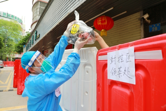 黄埔区支援白云区抗疫工作人员为封控区居民送上饭菜。