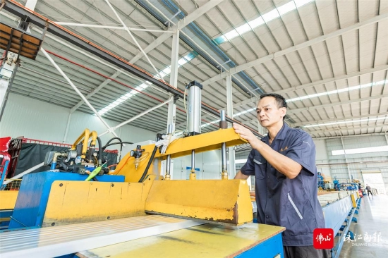 肇庆市尚乔铝业有限公司车间内,工作人员正在操作生产设备。