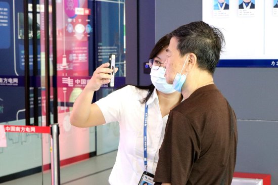 汕头市民小陈在办理低压用电新装业务时,在当地供电服务人员的帮助下,通过“南网在线”APP的“人脸识别”功能,轻轻划动手机就完成了业务办理。潘军 摄