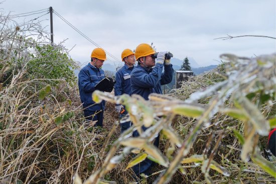 1月23日，南方电网广东清远阳山供电局阳城供电所工作人员采取“人巡+机巡”模式，仔细观察供电线路和配电设备的覆冰情况并记录。（彭海健 摄）