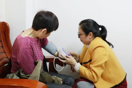 医院工会女工委主任陈红琴为田妹同志测量血压