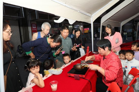  互动摊位上的民俗文化展示吸引众多群众围观。李剑锋 摄