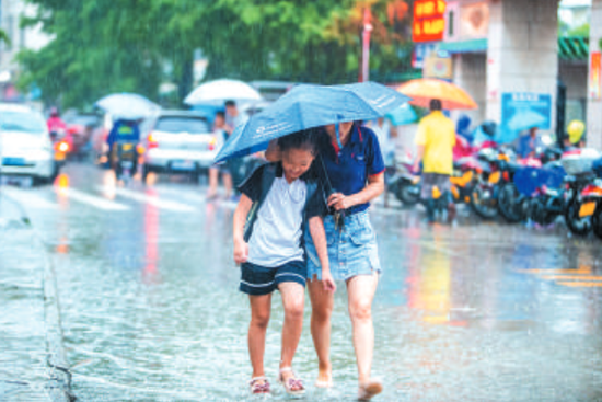 在伦教旧伦羊路,一位家长正在冒雨接送孩子