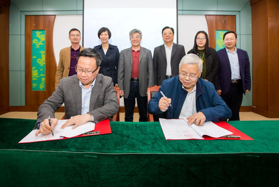 小榄镇党委书记梁荣佳（左）和广东省文化学会会长李明华（右）进行签约