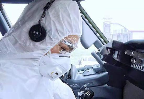 机长莫朝辉身穿防护服汗流满面在驾驶舱内进行航前准备工作。