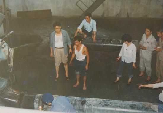 1987年,吴希荣在沙角电厂与工人一同处理事故。
