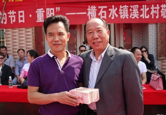 图为龙国强捐款后与受捐村民代表合影